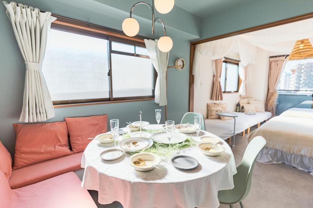 uma sala de jantar com uma mesa e um sofá em HARMONIA東京堀切502 em Tóquio