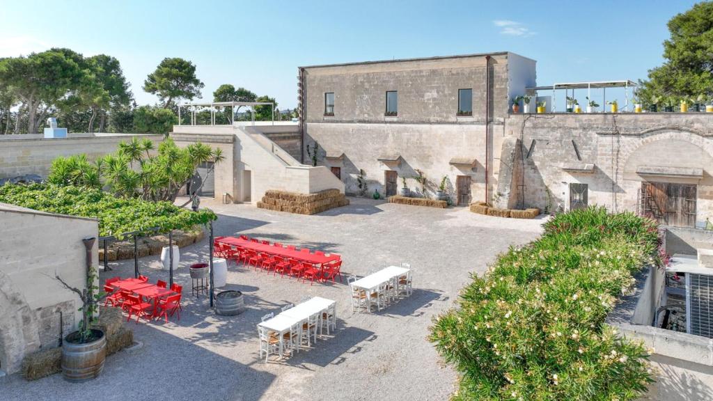 uma vista aérea de um edifício com mesas e bancos em Masseria Tenute Emera By Raro Villas em Lizzano