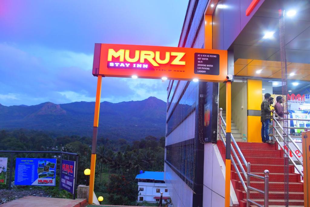una señal en el lateral de un edificio con escaleras en Muruz Stay Inn, en Gūdalūr