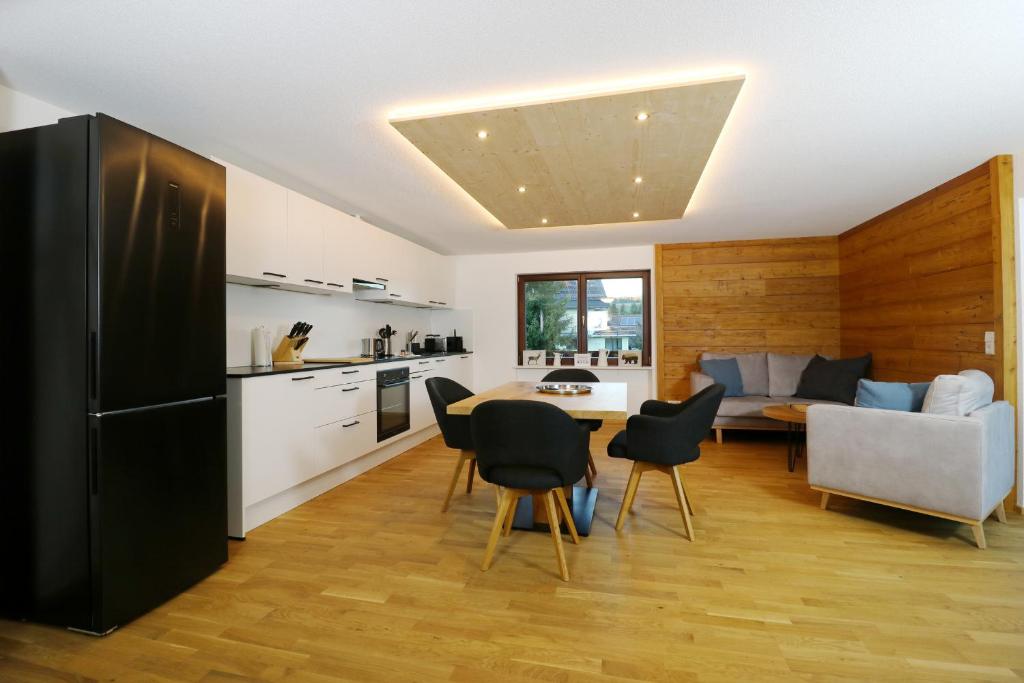 een keuken en een woonkamer met een tafel en stoelen bij Tannenhof Fischbach - Fewo 2 "Regenbogenforelle" - Schluchsee, 1 Schlafzimmer in Schluchsee