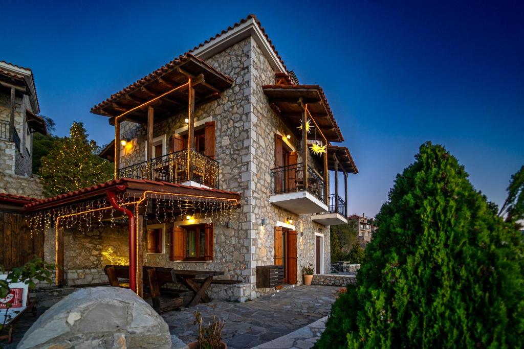 a stone house with a balcony and a tree at Rock Dandy Deluxe Chalet in Arachova - Delphi, Sauna, Prv Parking, Amazing View in Arachova