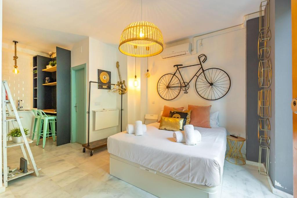 セビリアにあるDos de Mayo Loft by Valcambreのベッドルーム1室(壁に自転車を掛けたベッド1台付)