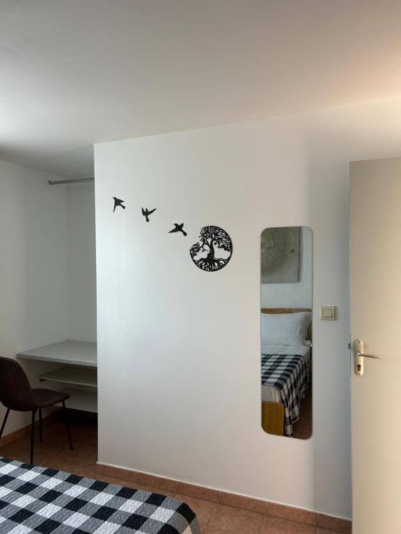 une chambre dotée d'un mur blanc avec trois décalamines d'oiseaux dans l'établissement TAN'MAYEVA APPART *, à Mamoudzou