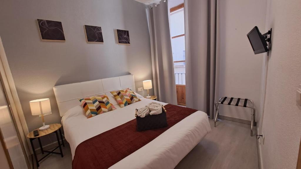 een slaapkamer met een bed met een rode deken bij Nest Style Granada in Granada