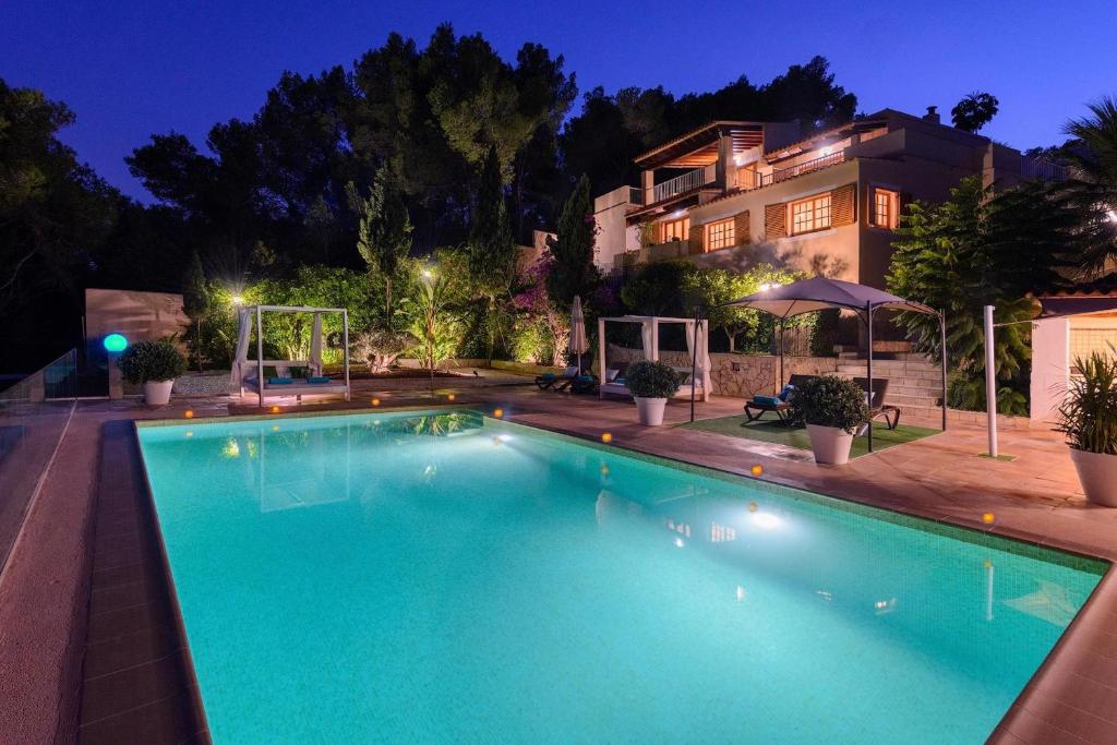 - une piscine en face d'une maison la nuit dans l'établissement Delightful Ibiza Villa - Spectacular Mountain Views - Villa Jasmine - 4 Bedrooms - Ibiza Town, à Sant Rafael de Sa Creu