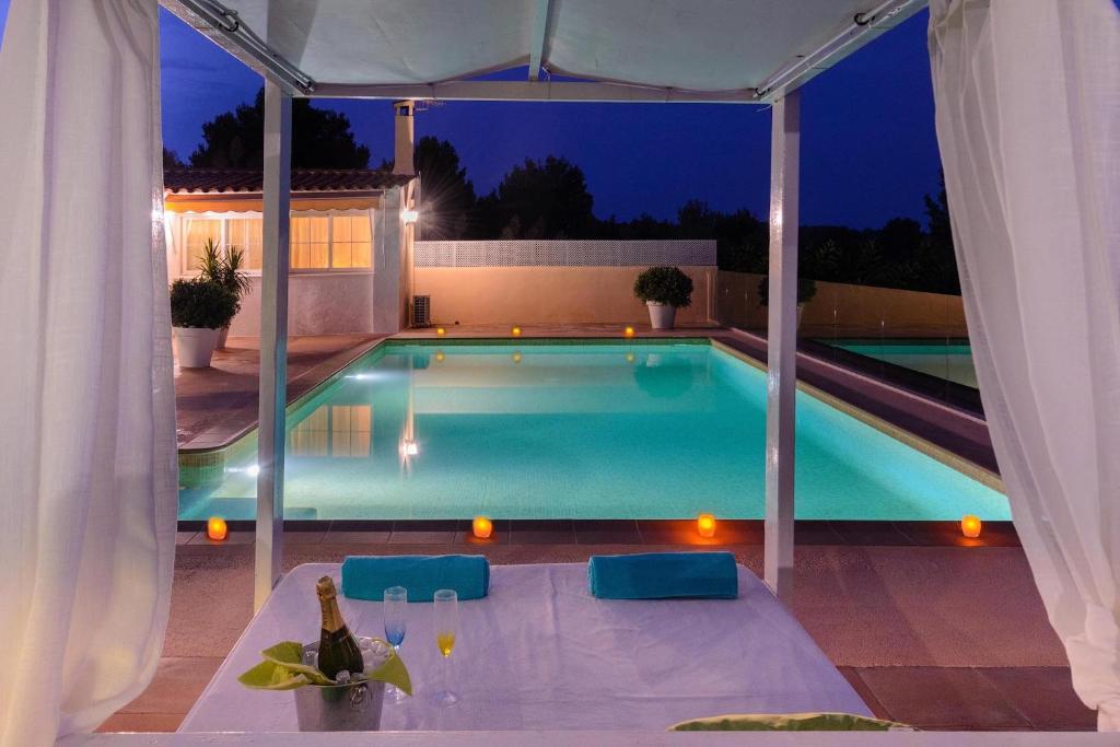 ein Swimmingpool in einem Hinterhof bei Nacht in der Unterkunft Delightful Ibiza Villa Spectacular Mountain Views Villa Jasmine in Sant Rafael de Sa Creu