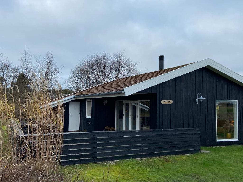 a black house with a fence in front of it at Holiday home Fanø VIII in Fanø