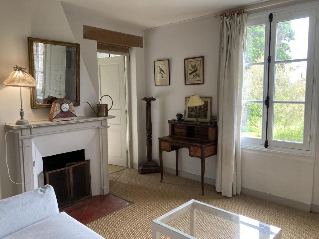 a living room with a fireplace and a mirror at Grand Clos Normand in Varengeville-sur-Mer