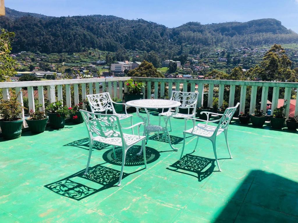 a group of chairs and a table on a balcony at Hikers Inn in Nuwara Eliya