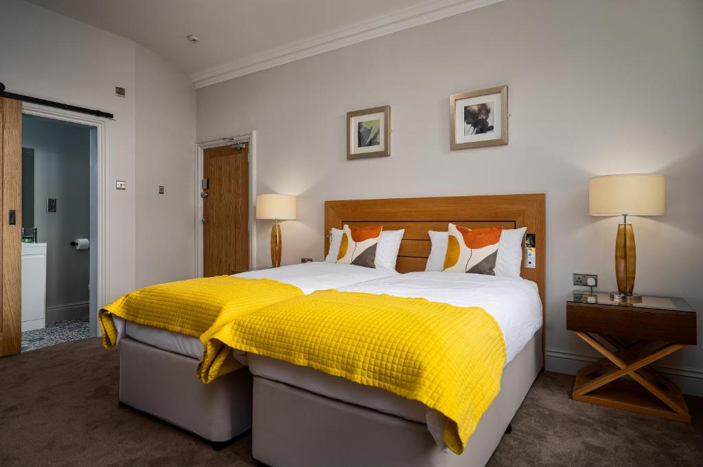 a bedroom with a large bed with a yellow blanket at Elephant and Castle in Wakefield