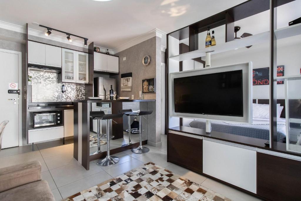 uma sala de estar com uma grande televisão e um bar em Apartamento 408 em condomínio de alto padrão em Guarulhos