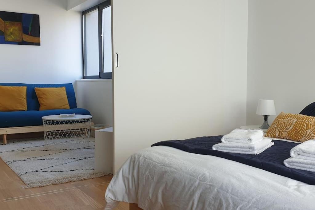 une chambre avec un lit et un canapé bleu dans l'établissement Contades Orangerie, à Strasbourg