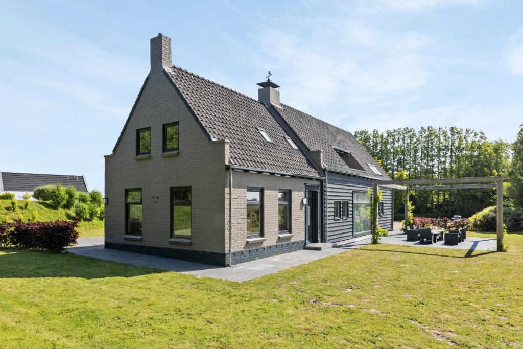 a small house with a grass yard at Landgoed Hermitage - Villa Euphoria - XXL Zwemspa - Max 10 personen in Ouddorp