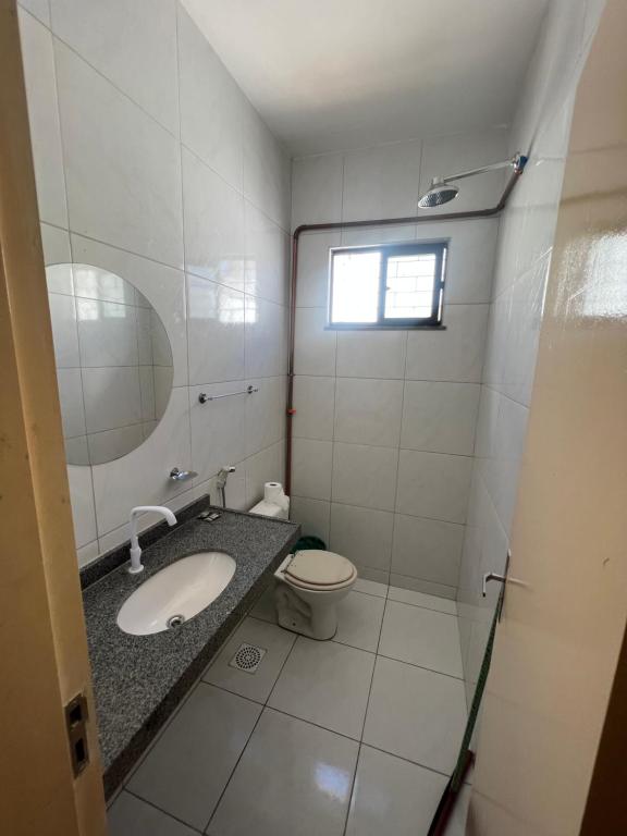 a bathroom with a sink and a toilet and a mirror at Ap no Derby com Garagem in Sobral