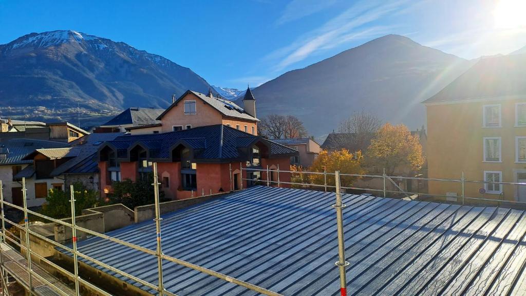 a rooftop of a building with a mountain in the background at Appartement d&#39;une chambre avec vue sur la ville et wifi a Embrun in Embrun