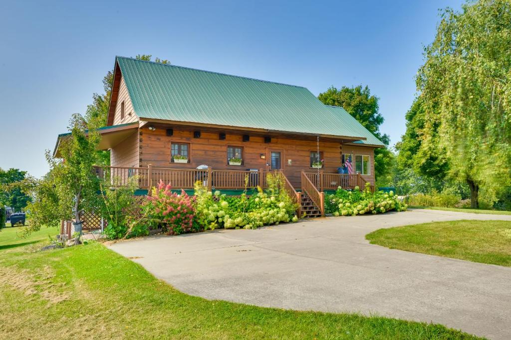 Casa de madera grande con techo verde en Warm and Cozy Clayton Cabin Near St Lawrence River!, en Clayton