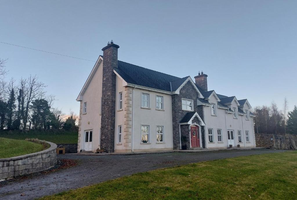 a large white house with a red door at Molly's Self Catering Accommodation in Cavan
