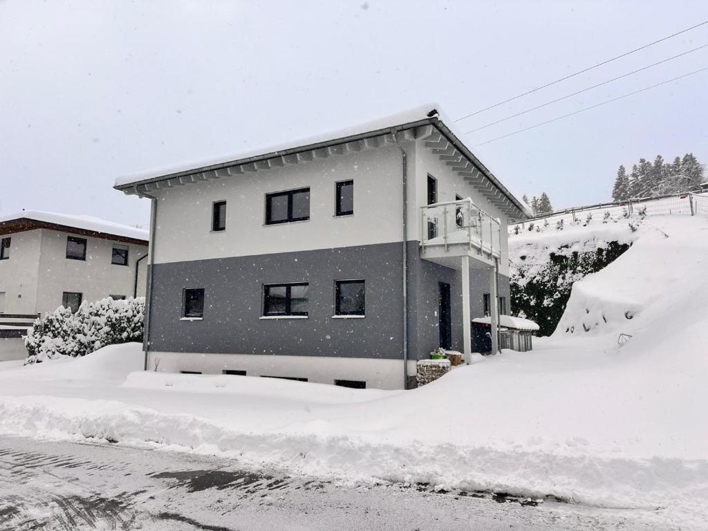 dom w śniegu z kupą śniegu w obiekcie Mountain Chalet w mieście Fieberbrunn