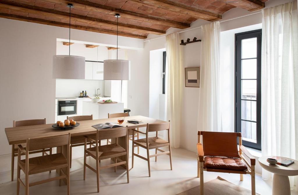 jadalnia z drewnianym stołem i krzesłami w obiekcie The Onsider - Luxury 2 Bedrooms Apartment in Gothic Quarter w Barcelonie