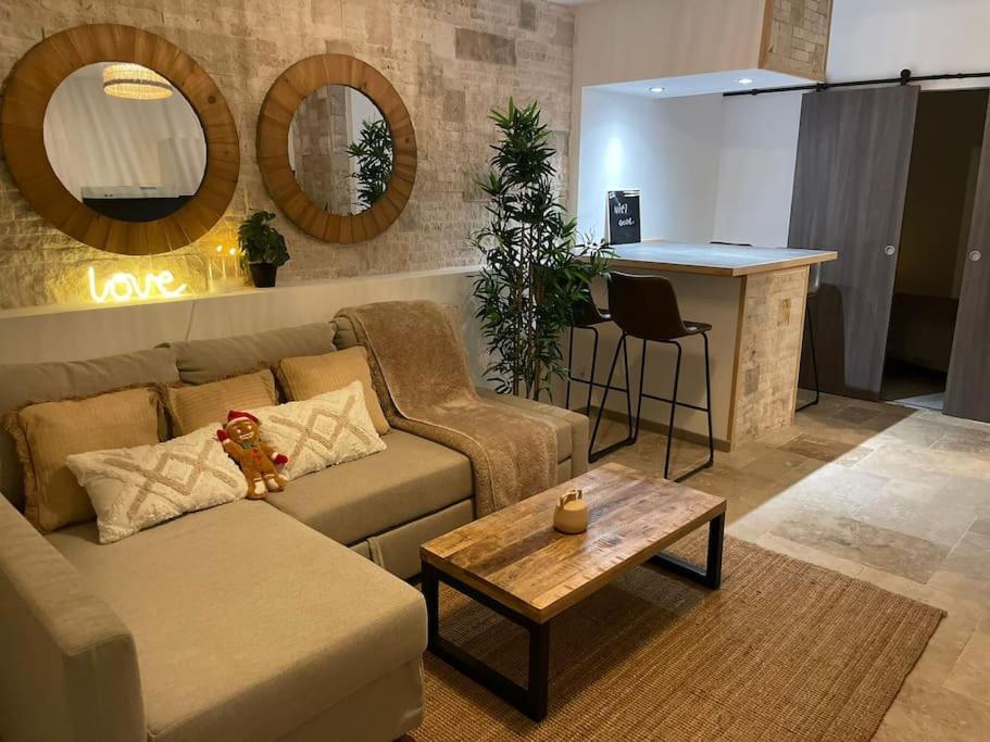 uma sala de estar com um sofá e uma mesa em Cosy, 2min Gare, work fun jacuzzi en juin em Bellegarde-sur-Valserine