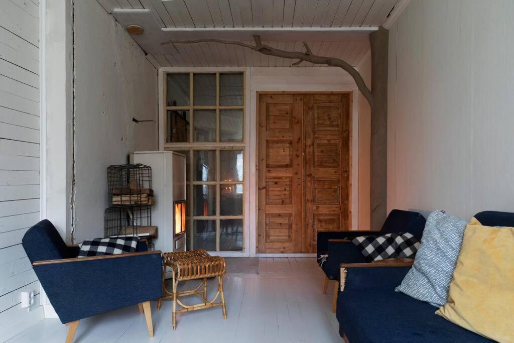 sala de estar con sofás azules y puerta de madera en Tunnelmallinen kaksio hirsitalossa, 