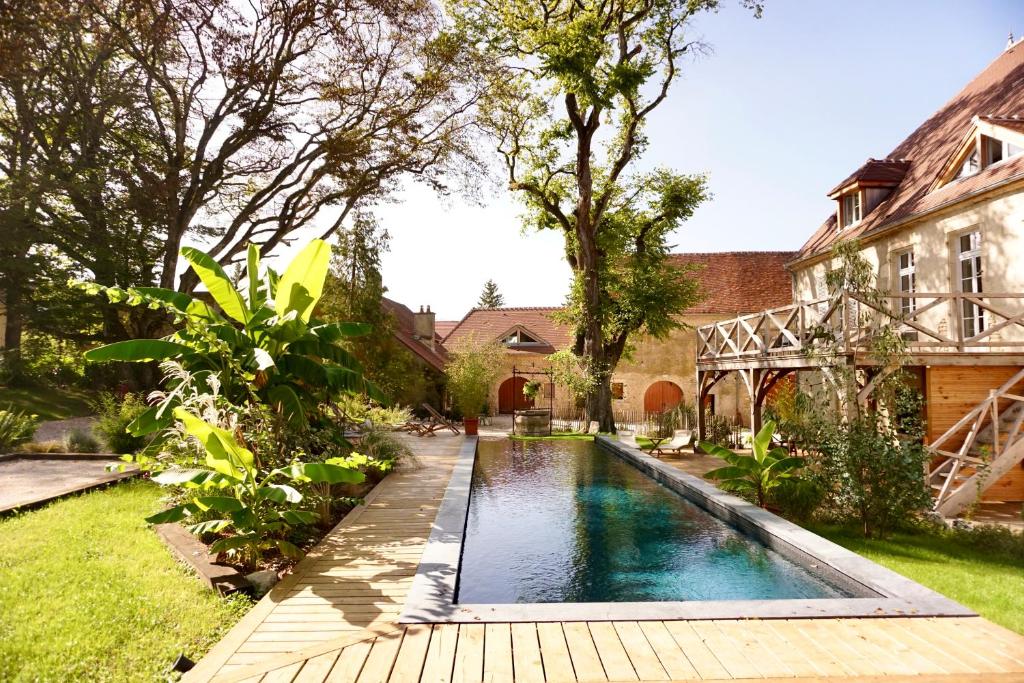 a swimming pool in the yard of a house at Les Chambres du parc 