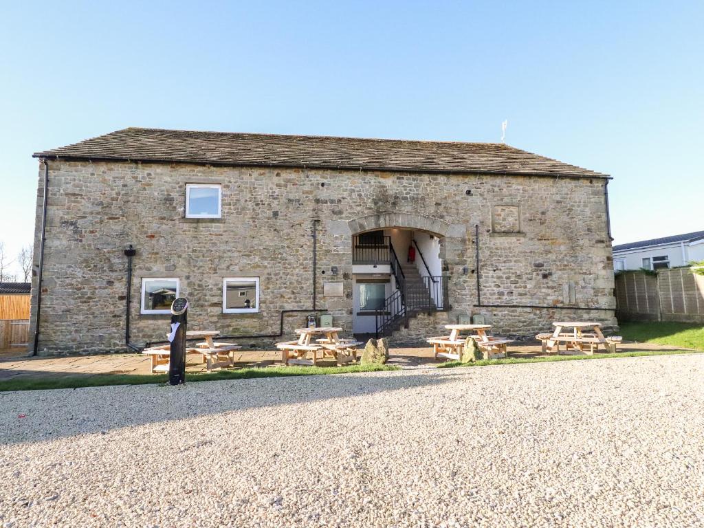 a stone building with picnic tables in front of it at Malham in Skipton