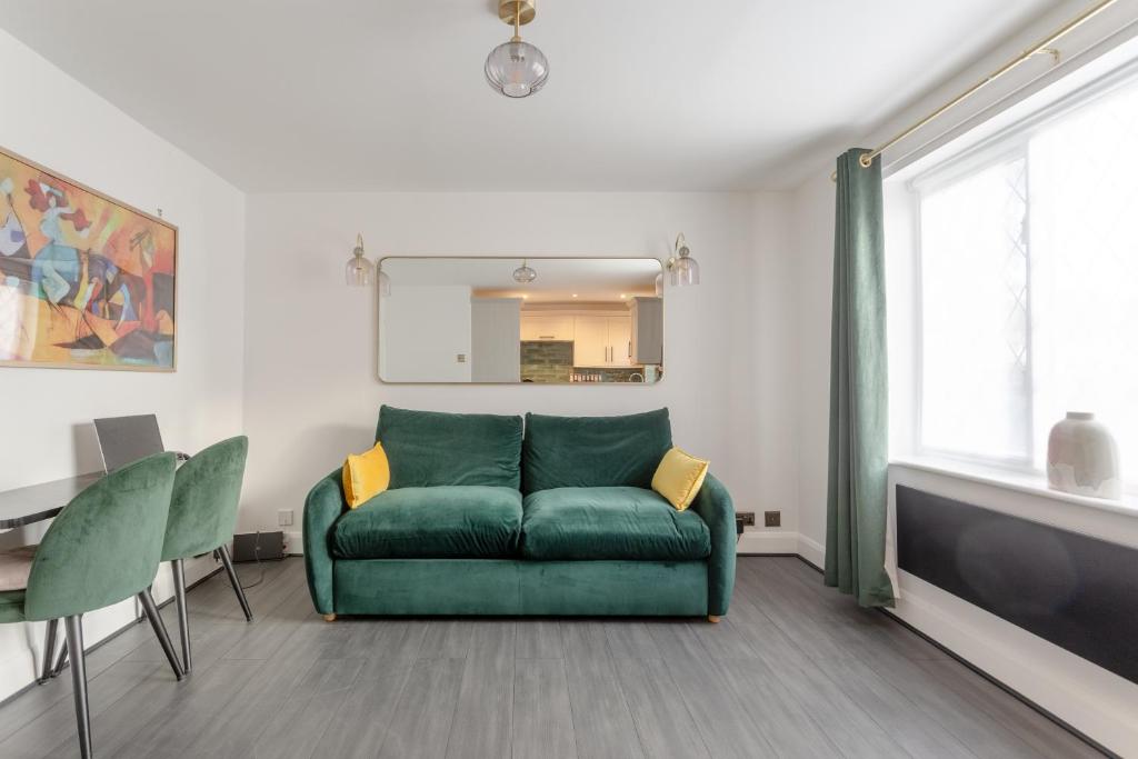 ein Wohnzimmer mit einem grünen Sofa und einem Spiegel in der Unterkunft 2 Double Beds Modern Refurb Flat - 10 min 2 London Bridge in London