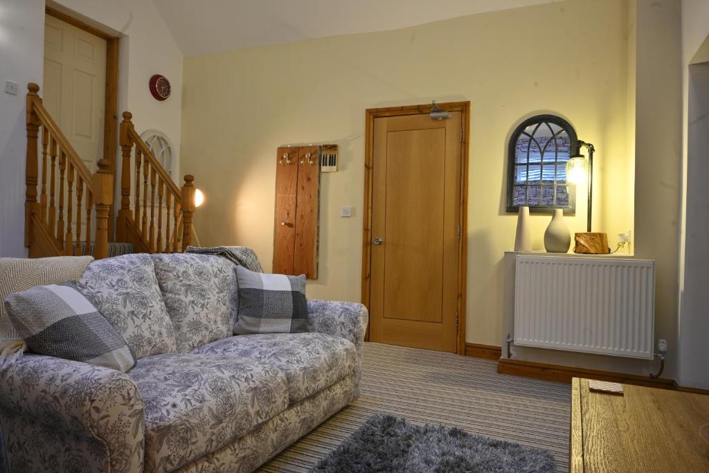 a living room with a couch and a window at The Little Pheasant Apartment Ironbridge Gorge in Broseley