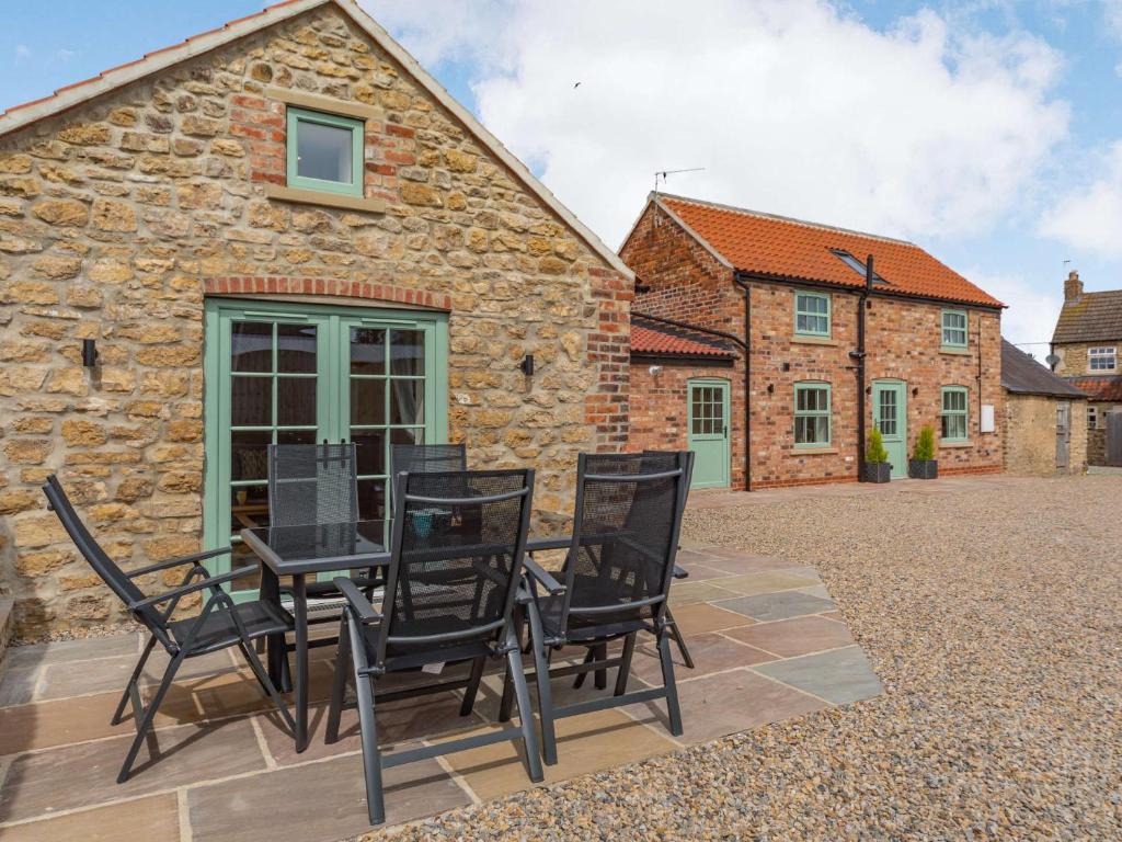 a group of chairs on a patio in front of a stone building at 3 bed in Bedale 88242 in Well