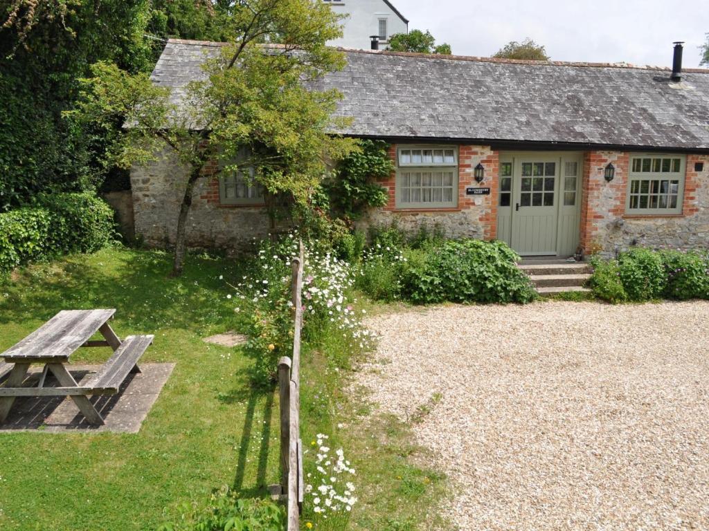 ein Cottage aus Stein mit einem Picknicktisch und einem Baum in der Unterkunft 2 bed property in Axminster BLOOM in Axminster