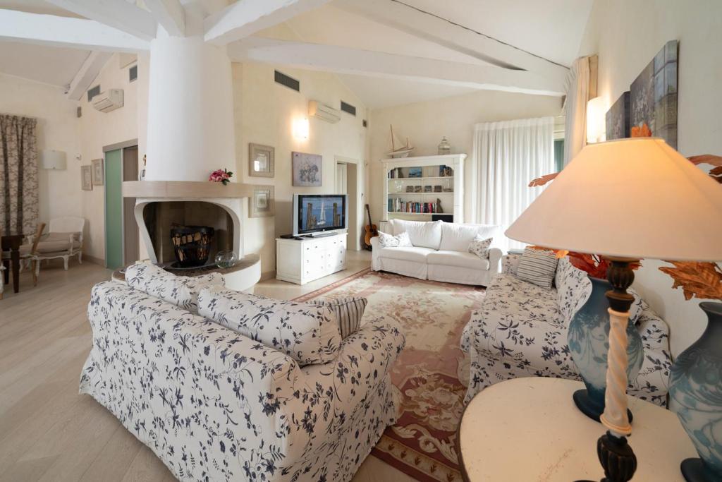 een woonkamer met 2 banken en een lamp bij VILLA INFINITY - Regarda Travel in Bardolino