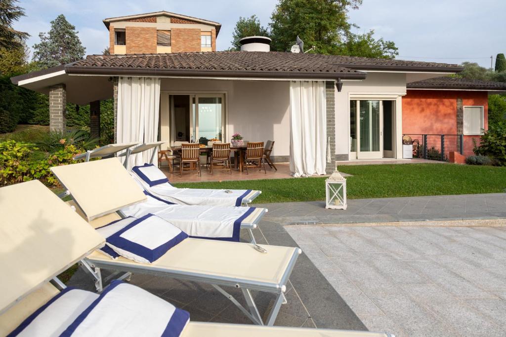 un groupe de chaises et de tables sur une terrasse dans l'établissement VILLA INFINITY - Regarda Travel, à Bardolino