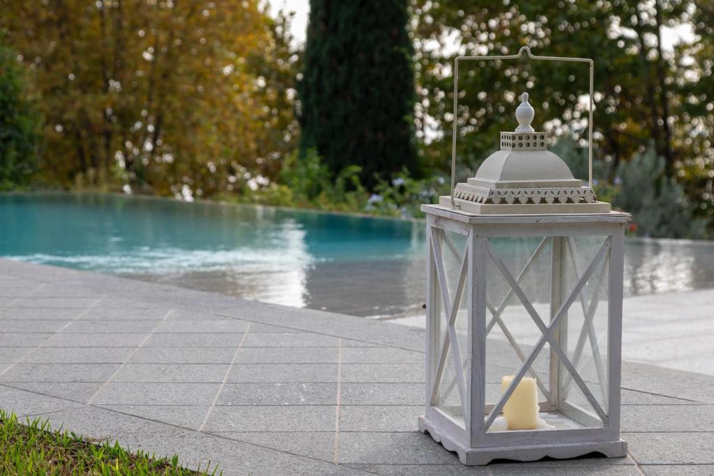 une lanterne posée sur un trottoir à côté d'une piscine dans l'établissement VILLA INFINITY - Regarda Travel, à Bardolino