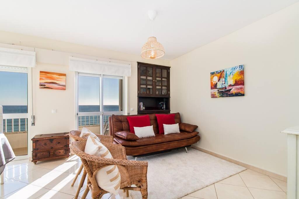una sala de estar con un sofá y una silla en Sea Side Apartment by SIDE VILLAS, en Armação de Pêra