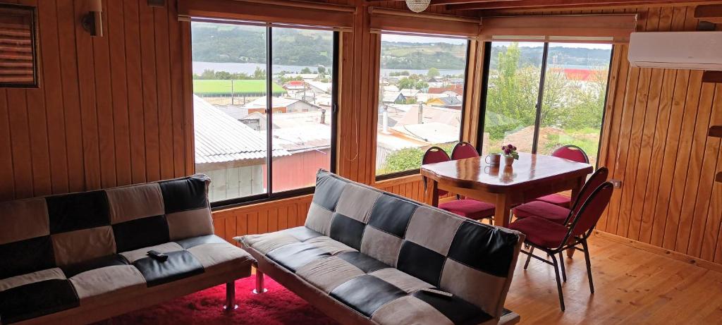 a living room with a table and chairs and a couch at Cabaña piedra azul in Dalcahue