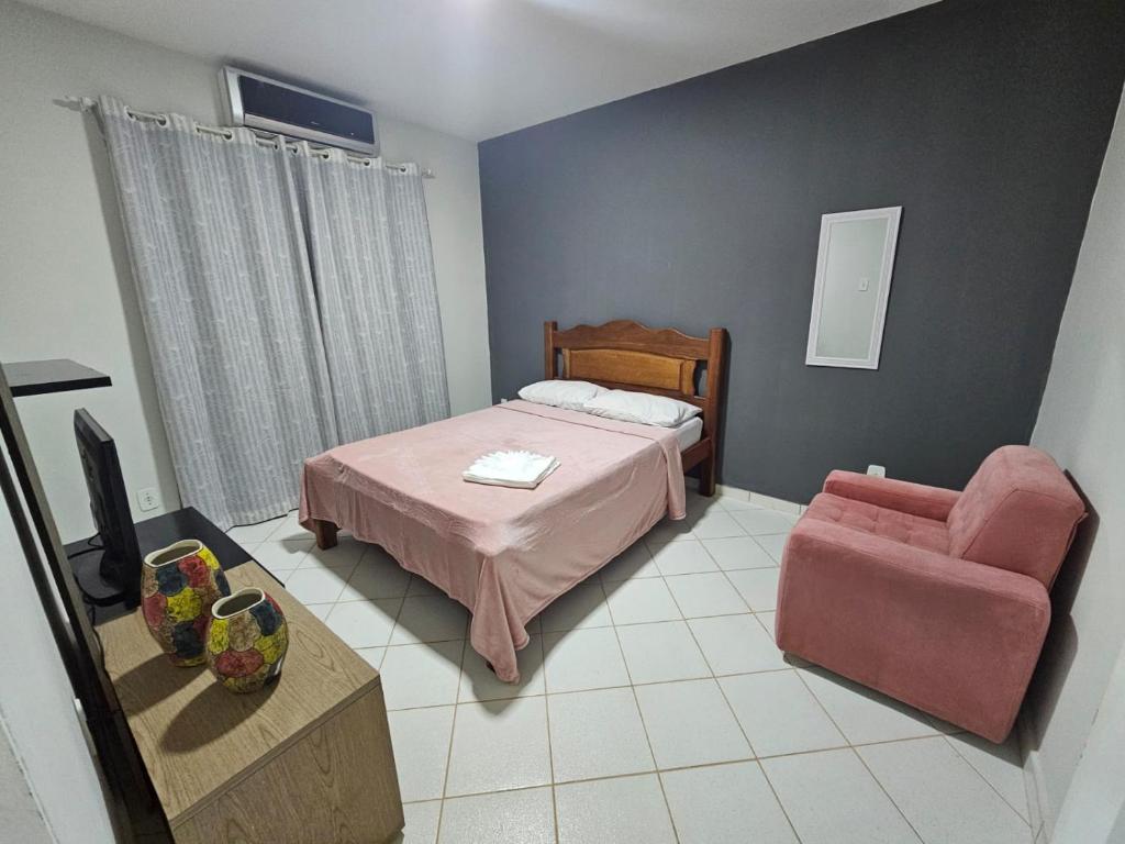 a bedroom with a bed and a chair at Apto novo, mobiliado e acochegante in Boa Vista