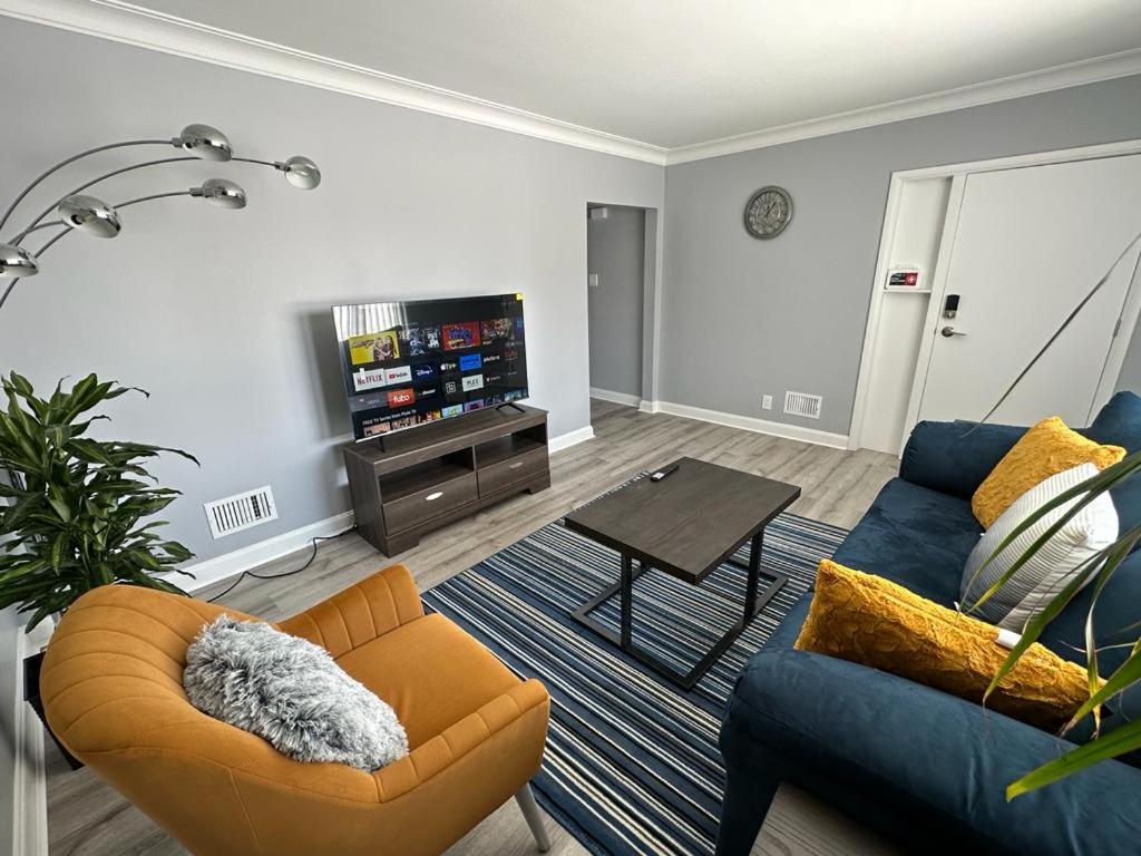 uma sala de estar com um sofá e uma televisão em Spotless 2 Bedroom Suite in Winnipeg em Winnipeg