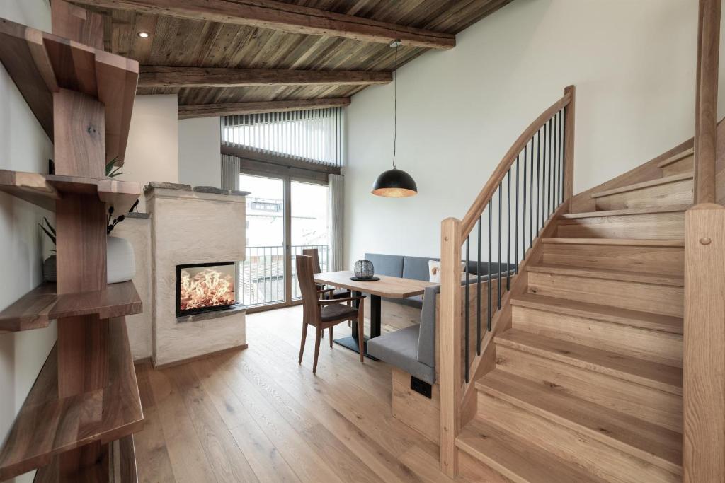 a dining room with a table and a fireplace at Alpine Lofts M26 in Grossarl