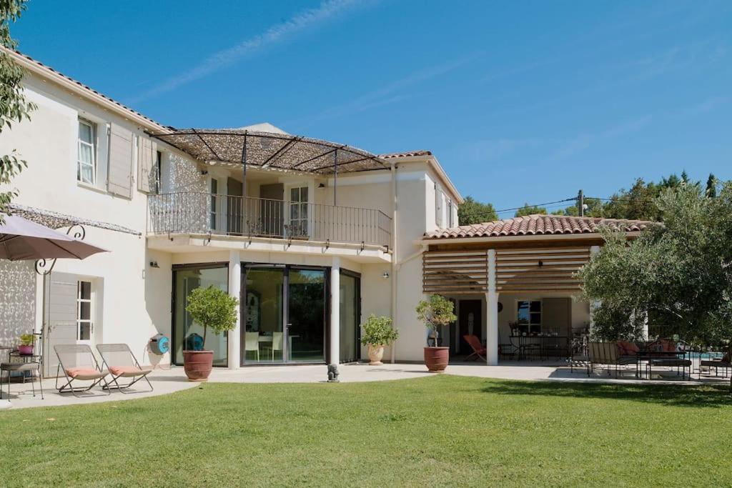a house with a balcony and a yard at Demeure de charme, piscine, centre St Rémy à pied in Saint-Rémy-de-Provence