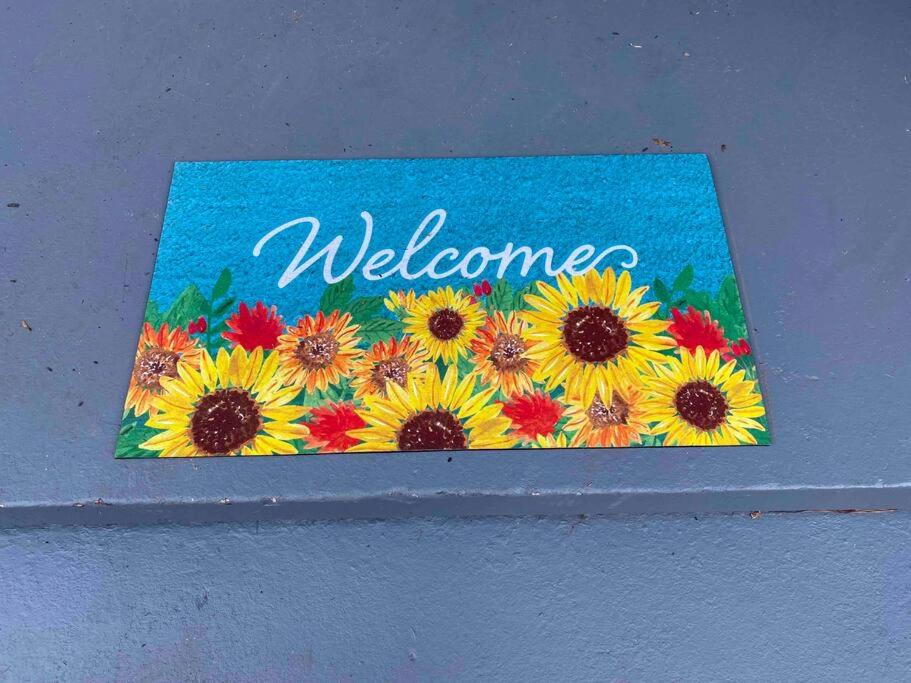 a welcome sign with a bunch of sunflowers at Downtown Hidden Gem in Columbia
