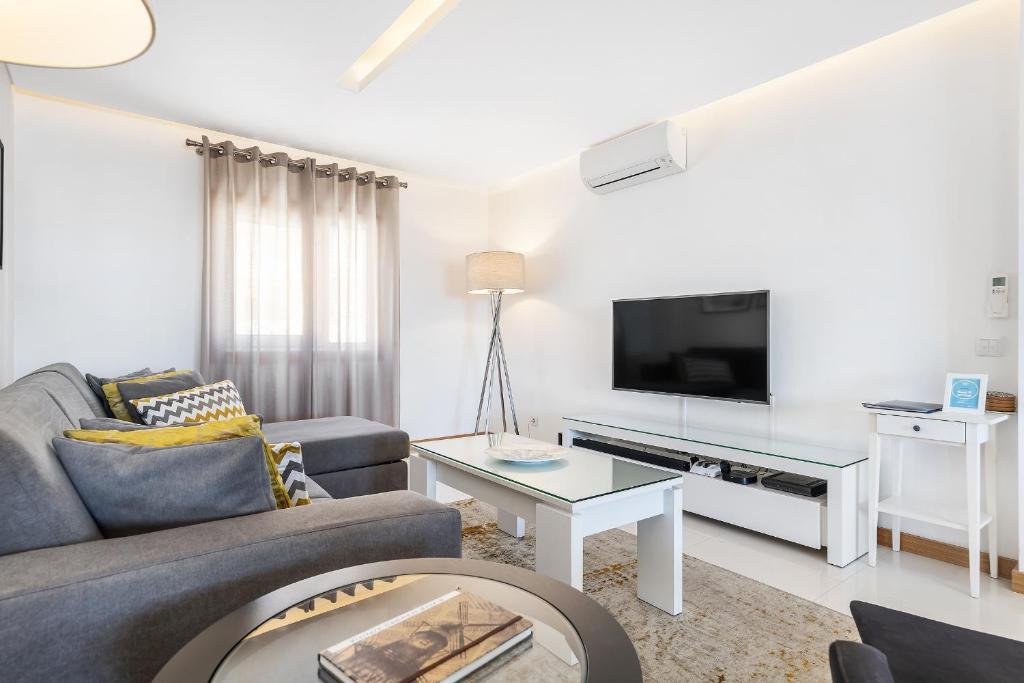 a living room with a couch and a tv at Garden Hill Relax & Old Town by OCvillas in Albufeira