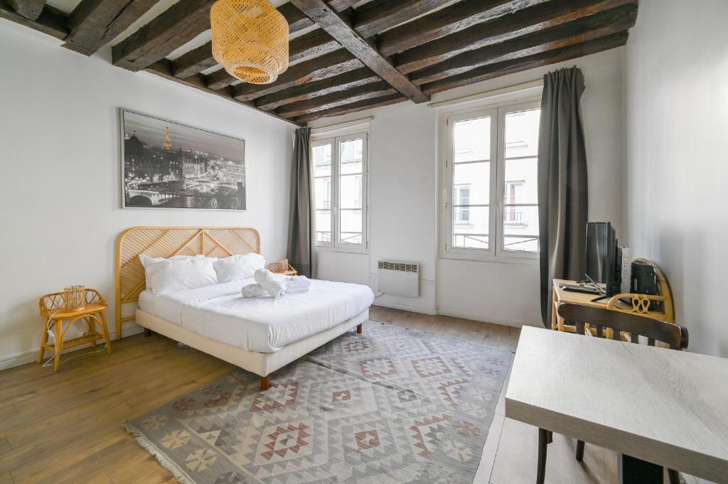 une chambre avec un lit blanc et une table dans l'établissement Cléry 43, à Paris