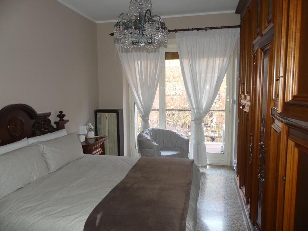 1 dormitorio con cama, lámpara de araña y ventana en SERVETTOHOME en Turín