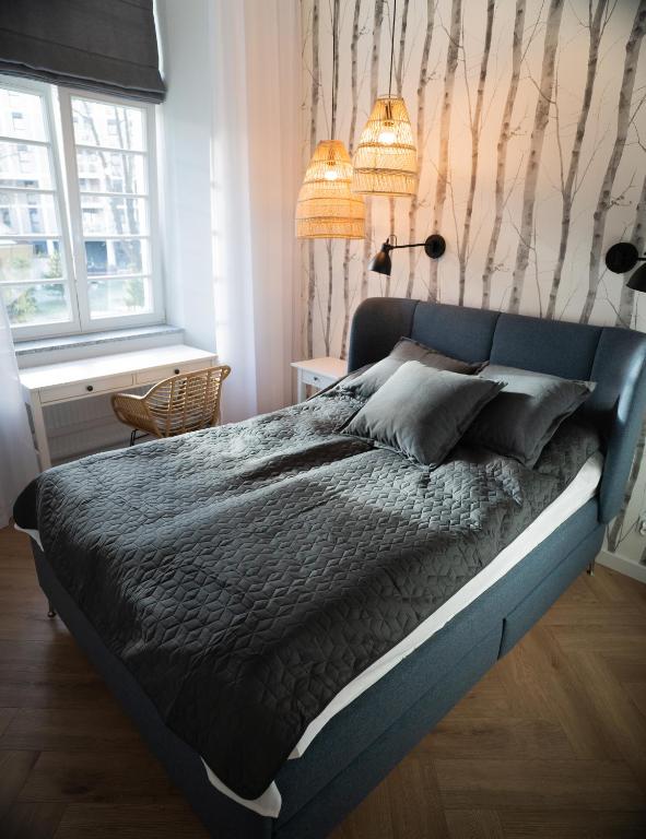 1 dormitorio con 1 cama grande y cabecero azul en Premium Apartment - Old Town Jana Pawła II en Wroclaw