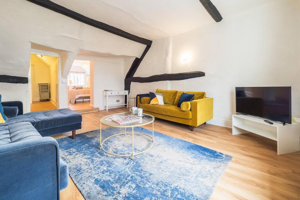 a living room with a couch and a tv at Hamlet's Nest in Stratford-upon-Avon