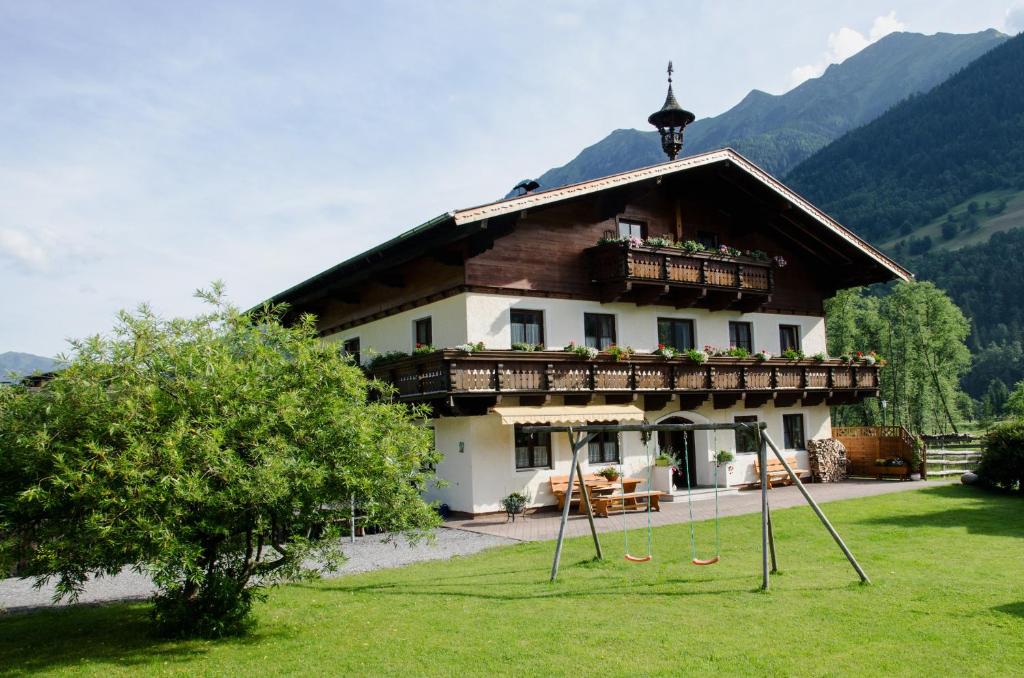 une maison avec une aire de jeux en face dans l'établissement Scheibenhof, à Bad Gastein