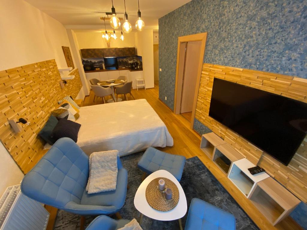 a hotel room with a bed and a flat screen tv at Apartmány Impresia - Bernard in Vysoké Tatry