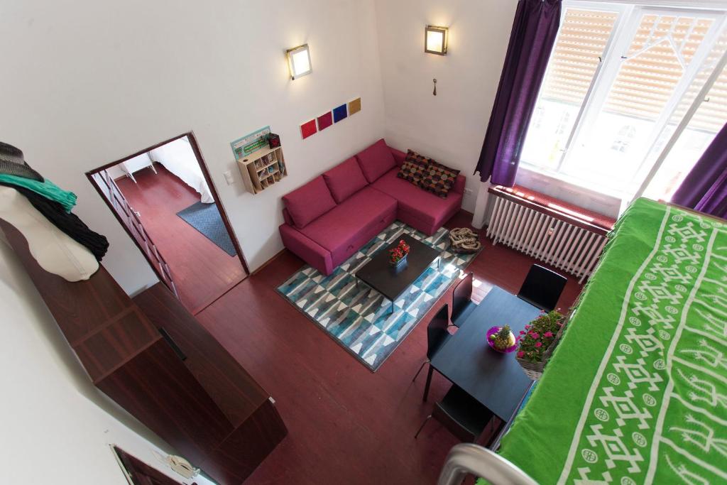 ブダペストにあるApartment Egusiのピンクのソファ付きのリビングルームのオーバーヘッドビュー