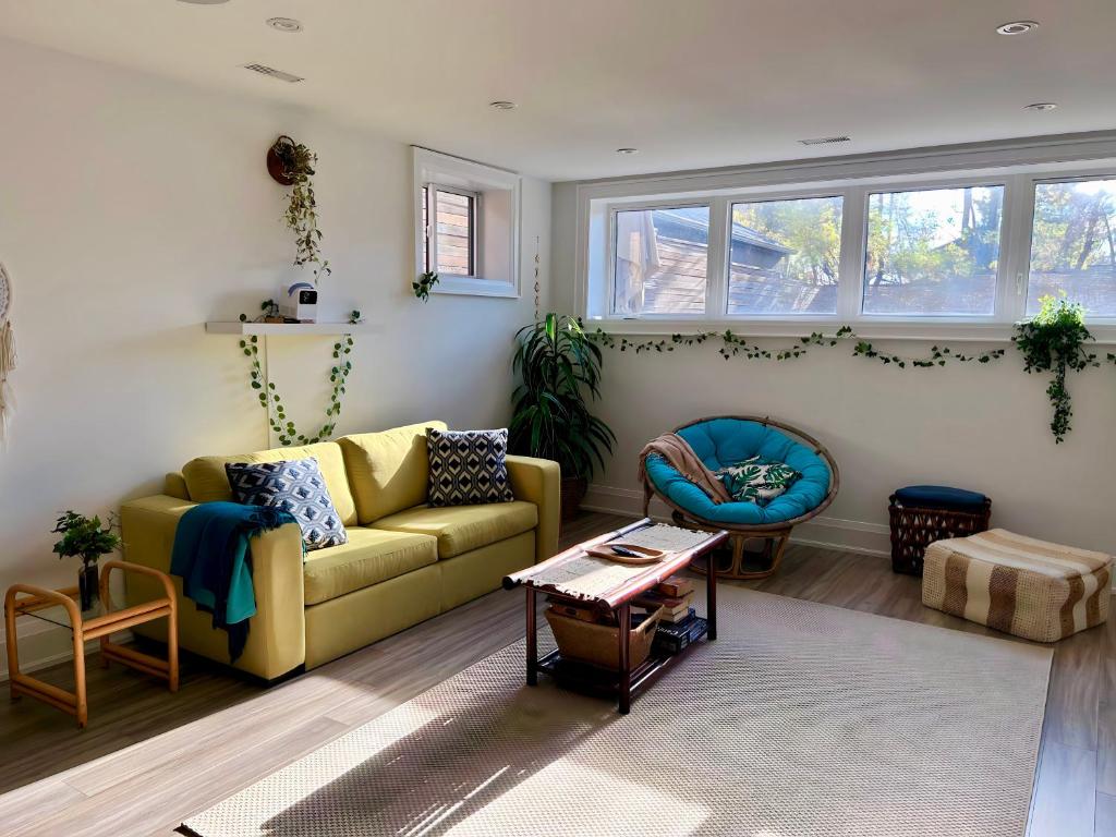 a living room with a yellow couch and a table at Boho-chic Spacious Basement Apartment in Toronto